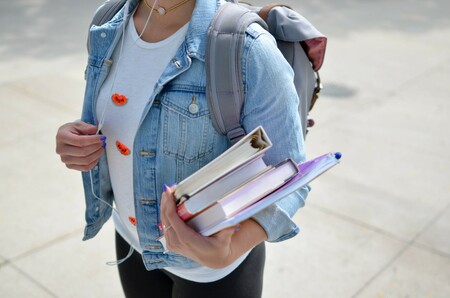Girl holding books and wearing backpack